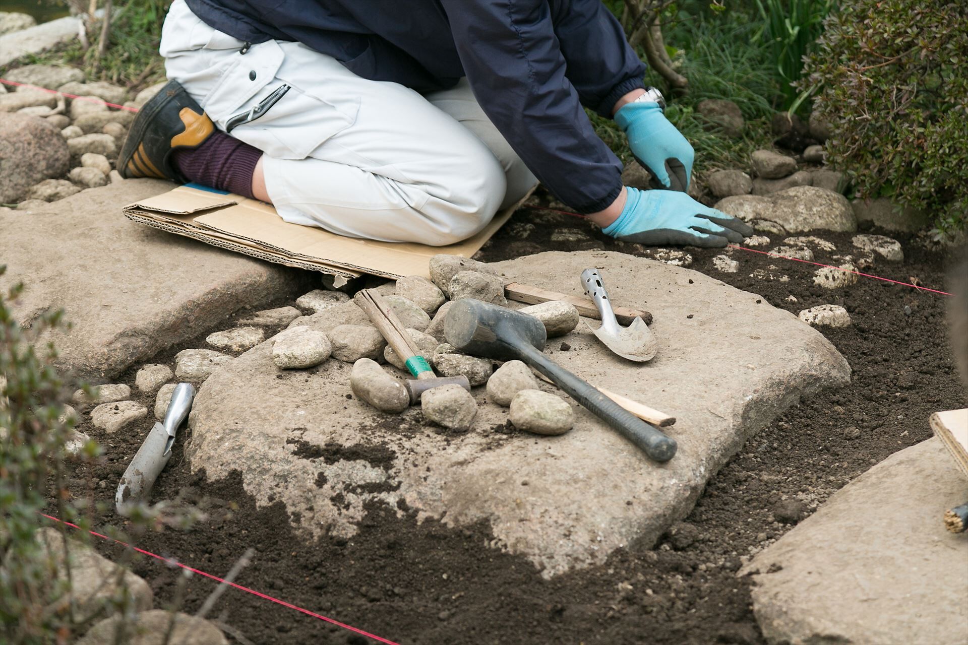 庭の石を取り除くスタッフ